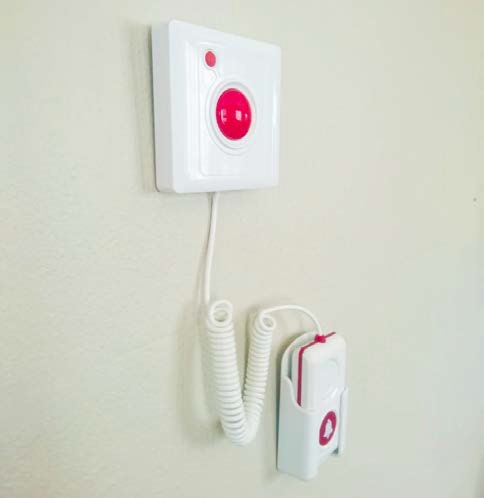 BellMe B-SW-G33 Call & Cancel Integrated with Cord mounted on a wall, with the coiled cord and extended call button hanging below