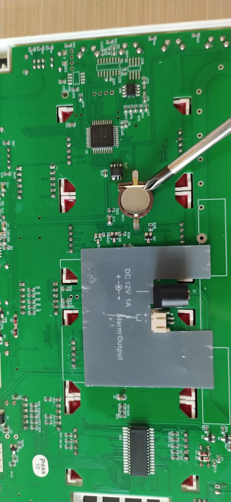 The B-99G main circuit board with the CR1220 coin battery being changed